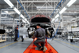 Worker in front of part-assembled car