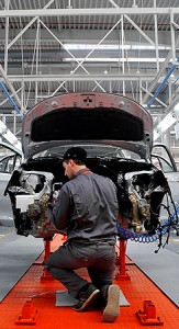 Worker in front of part-assembled car