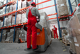 Two warehouse workers moving boxes