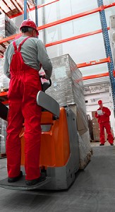 Two warehouse workers moving boxes